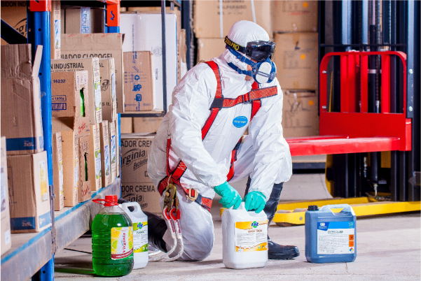 Man in protective clothing and harness opening chemicals