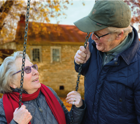 Older man looking at older lady on swing