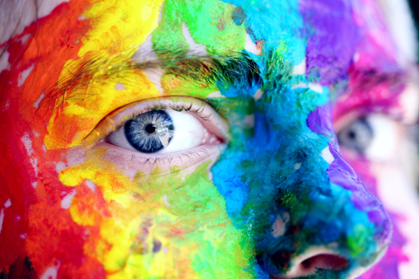 Part of face showing eyes with rainbow paint over face